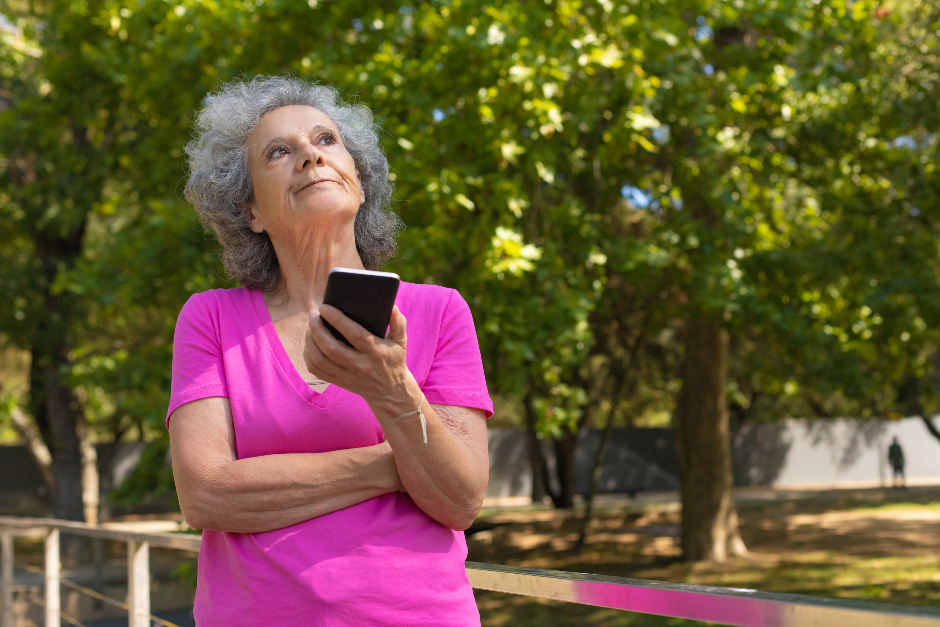 Pensive old lady with cellphone typing message