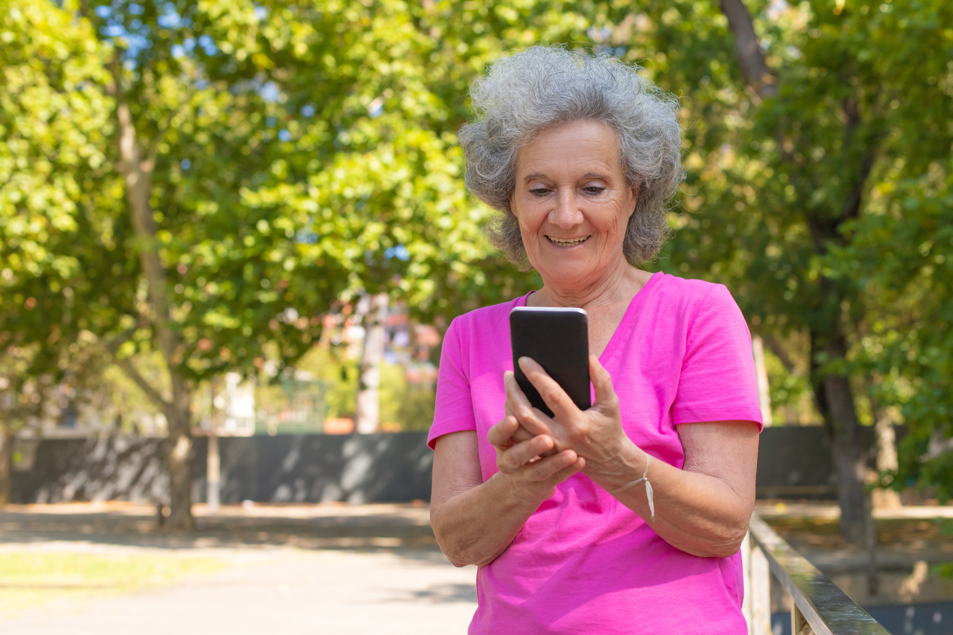 Joyful happy old lady using cellphone for video call